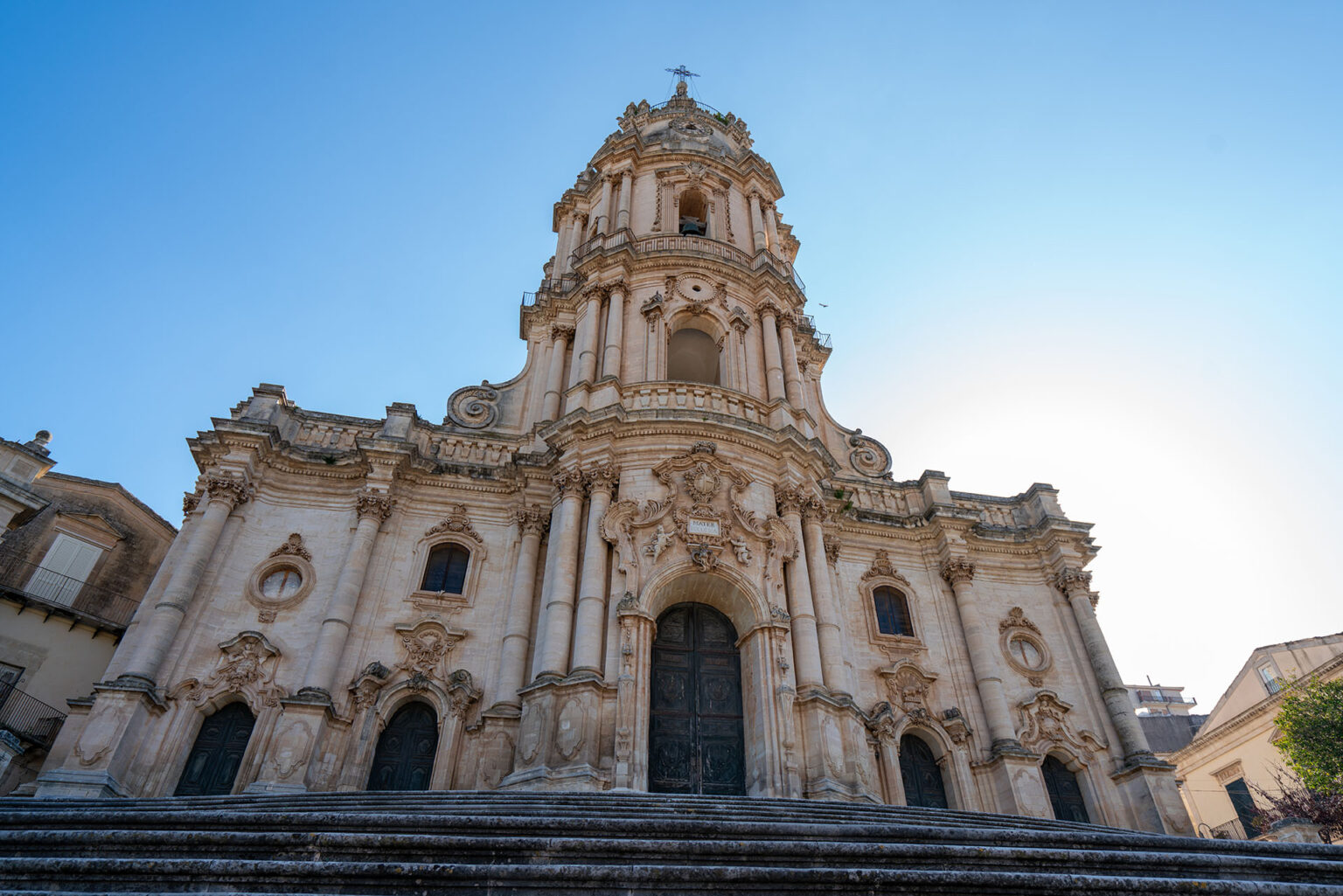 "La maestosa Cattedrale di Noto vista da un arco in pietra: un'escursione imperdibile nel Barocco Siciliano partendo dal Castellett Ragusa.