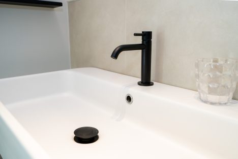 Lavabo di design con rubinetteria nera opaca, dettaglio arredo bagno Stanza Luigi presso Castellett Ragusa.